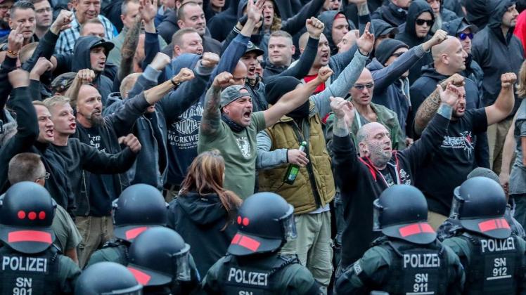 Demonstranten aus der rechten Szene gestikulieren und drohen bei einer Kundgebung in Chemnitz. Foto: Jan Woitas/ZB/dpa