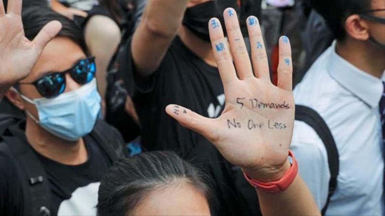 „Fünf Forderungen, nicht eine weniger“ steht auf der Handfläche einer Demonstrantin. 