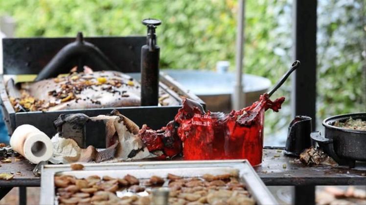 Verbrannte Grill-Utensilien liegen auf einem Tisch. Bei dem Fest gab es eine verheerende Explosion. 