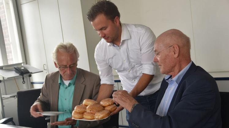 Dankeschön für gute Zusammenarbeit: Schausteller Symon Veldkamp (Mitte) serviert Oberbürgermeister Axel Jahnz (v.l., SPD) und Bürgermeister Hermann Thölstedt (CDU) die traditionellen Berliner. 