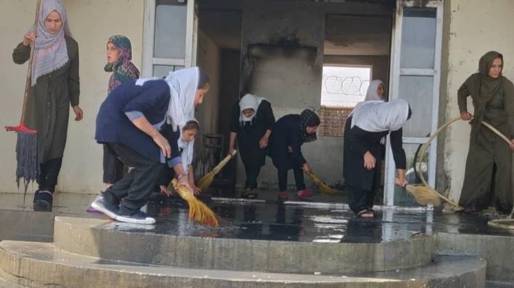 Aufräumen nach dem Anschlag: Schülerinnen übernehmen die Reinigung der russigen Wände und Böden. 