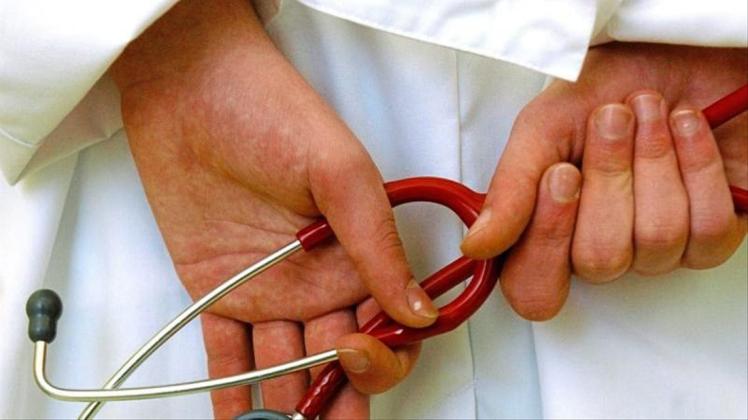 Ein Arzt hält ein Stethoskop in den Händen. 