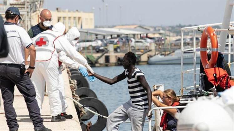 Migranten verlassen im Hafen von Pozzallo auf Sizilien ein Rettungsschiff. 
