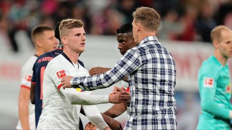 Leipzigs Werner (l) und Trainer Nagelsmann (M) klatschen sich nach dem Unentschieden gegen den FC Bayern München ab. 