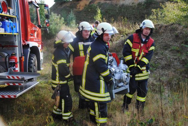 Durch unwegsames Gelände transportierten die Feuerwehrleute diese Tragkraftspritze. Foto: Björn Thienenkamp Durch unwegsames Gelände transportierten die Feuerwehrleute diese Tragkraftspritze. Foto: Björn Thienenkamp