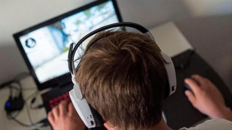Ein junger Mann spielt ein Online-Computerspiel. 
