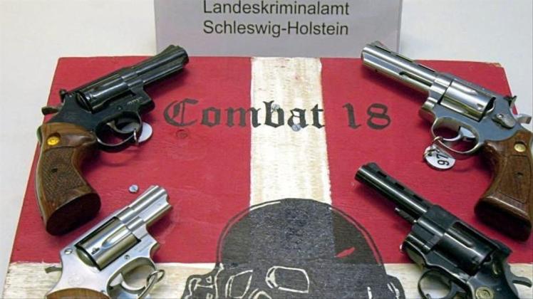 Sichergestellte Waffen und ein Schild der Neonazi-Gruppe „Combat 18“ im schleswig-holsteinischen Landeskriminalamt. 