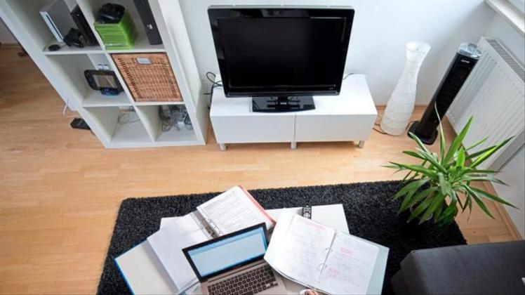 Zu Hause statt im Büro: Eine Frau arbeitet in einem Wohnzimmer an einem Laptop. 