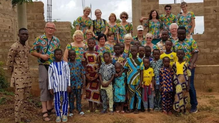 Die Reisegruppe der St. Martinus-Gemeinde Hagen zusammen mit Kindern aus Benin vor der Baustelle, auf der eine neue Schule und ein Kindergarten enstehen soll. 