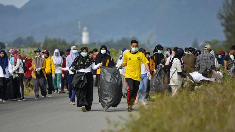 Schüler und Studenten sammeln in Banda Aceh auf Sumatra Müll aus der Landschaft. Foto: AFP/CHAIDEER MAHYUDDIN