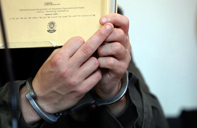 Der angeklagte Stiefvater zeigt den Mittelfinger Richtung Anklage. Foto: dpa/Bernd Wüstneck
