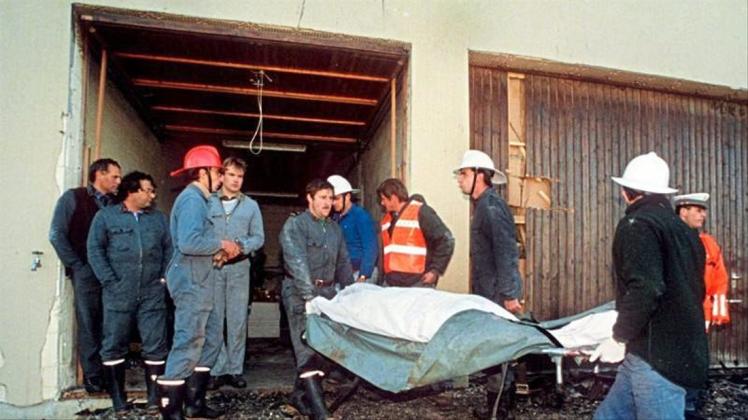 Polizei und Feuerwehrleute tragen am 5. Oktober 1994 die tot aufgefundenen Sektenmitglieder aus dem Haus in Cheiry im Kanton Freiburg. Hier starben zehn Männer, zwölf Frauen und ein Kind. 