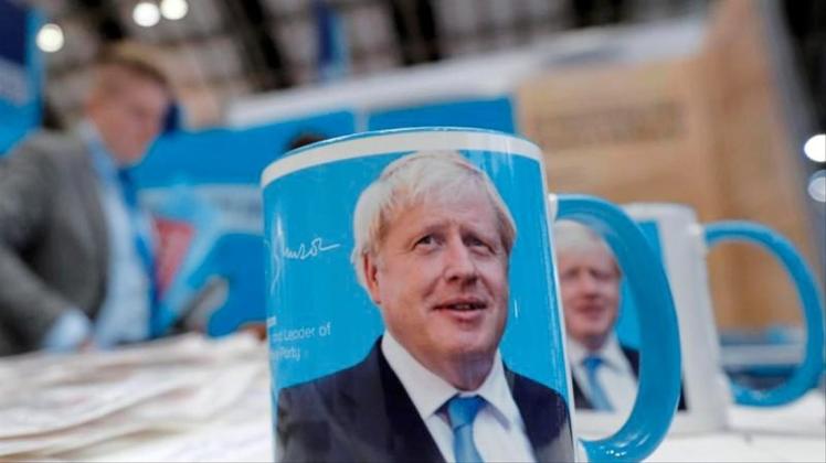 Tassen mit dem Gesicht von Premierminister Boris Johnson auf dem Parteitag. 