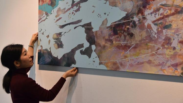 Willi-Oltmanns-Preisträgerin Chika Aruga beim Hängen ihres Werkes „Suche nach den Spuren“. Foto: Henrik Schaper