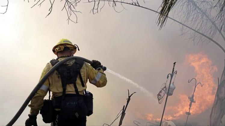 Ein Feuerwehrmann ist bei einem Waldbrand in Santa Clarita im US-Bundesstaat Kalifornien im Einsatz. 