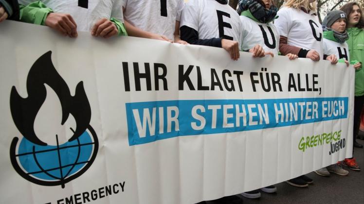 Demonstranten stehen vor dem Berliner Verwaltungsgericht. Die Kläger sehen ihre Existenzgrundlage durch den Klimawandel bedroht und ihre Grundrechte verletzt. Foto: Paul Zinken/dpa
