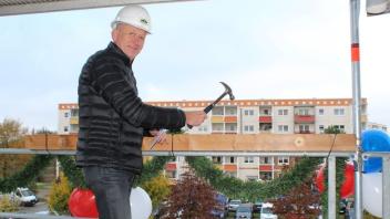 Die Vorfreude ist groß: WG Union-Vorstand Volker Fritz setzt beim Richtfest zum traditionellen Nagelschlagen an. Bis Ende nächsten Jahres sollen die 37 neuen Wohnungen fertig sein.