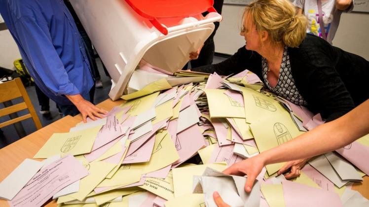 Wahltag im Mai: Eine Hamburger Wahlhelferin leert die Wahlurne für die Auszählung der Stimmen. Foto: dpa