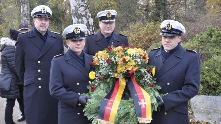 Auch die Deutsche Marine legt einen Kranz nieder: Oberstabsbootsmann Steffen Gehrke (l.) und Fregattenkapitän Dirk Koop (hinten) begleiten die Oberstabsgefreiten Vanesse Bizjak und Dirk Engel zum Gedenkstein.