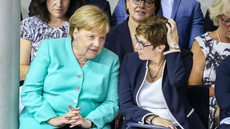 Bundeskanzlerin Angela Merkel (l, CDU) spricht mit Annegret Kramp-Karrenbauer, CDU-Vorsitzende und Verteidigungsministerin. Die 56-Jährige war zuvor in diesem Amt vereidigt worden.