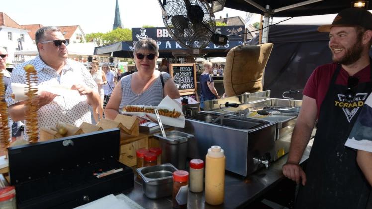 Na dann, guten Appetit: Thorsten Grüß (rechts) überreichte am Sonntag diesen beiden Gästen auf dem Marktplatz je einen "Kartoffel-Tornado". Foto: Thomas Pertz