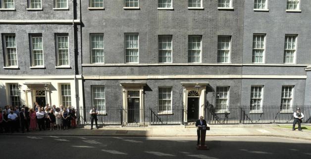 In 10 Downing Street (hinter Johnson) wird künftig der Finanzminister wohnen. Johnson und seine Freundin ziehen nebenan ein (hinter der Menschenmenge links) in die Hausnummer 11. Foto: AFP/ ISABEL INFANTES