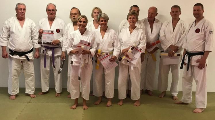 Die erfolgreichen Prüfungsteilnehmer der Ü-50-Karategruppe und weitere Absolventen aus dem Meller Karate zusammen mit Trainer Wolfgang Tempelmeier (links) und dem Budokai-Leiter Ralf Kruckemeyer (rechts). Foto: Kruckemeyer