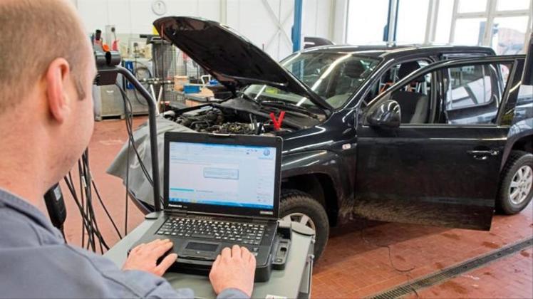 Ein Kfz-Meister lädt ein Software-Update für das Steuergerät der Motorelektronik auf einen Volkswagen Amarok mit Dieselmotor. 