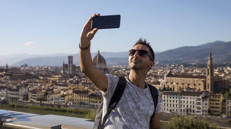 Selfies gehören auf Reisen einfach dazu, besonders, wenn die besuchte Stadt im Hintergrund zu sehen ist.
