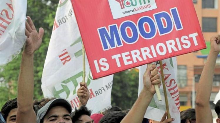 Kritik an Indiens Premierminister: Ein pakistanischer Demonstrant hält bei einer Kundgebung ein Schild in die Höhe. 