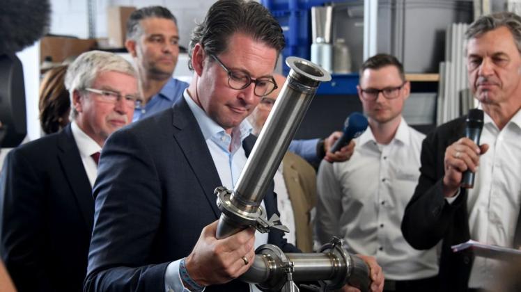 Im Sommer 2018 besuchte Bundesverkehrsminister Andreas Scheuer (CSU) das Hauptabgaslabor des Kraftfahrt-Bundesamtes und hantierte mit einem Rohr aus einem Abgas-Messgerät. Foto: dpa/Carsten Rehder