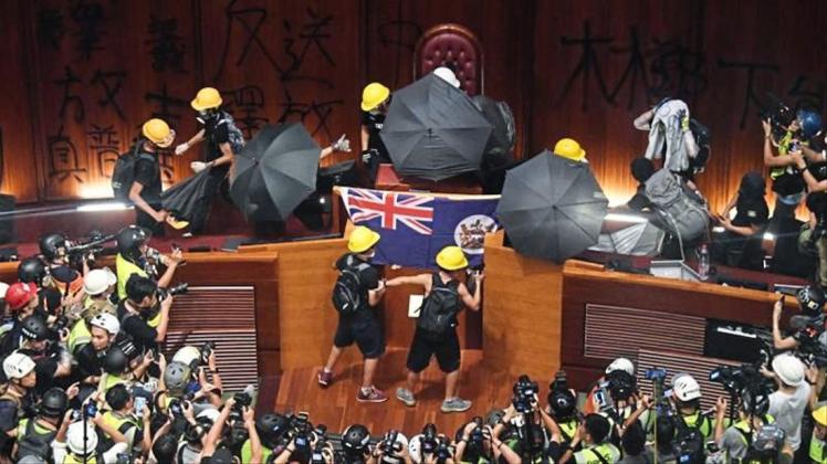 Demonstranten hissen im Hongkonger Parlament die Flagee der ehemaligen britischen Kolonie. 