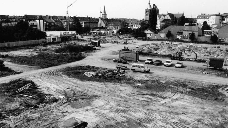 Das Baufeld für die Tiefgarage und das Sanierungsgebiet Salzmarkt ist im August 1994 vorbereitet. Der Blick vom Baukran geht nach Nordwesten mit den Türmen von St. Katharinen und St. Johann im Hintergrund. 