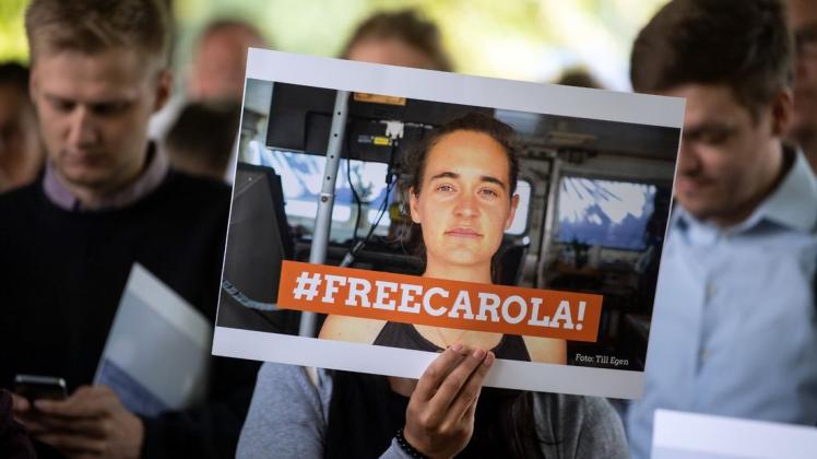 Solidaritätskundgebung: Eine Demonstrantin hält ein Bild von Carola Rackete mit der Aufschrift "#FREECAROLA!" in der Hand. Mit einer Mahnwache haben am Dienstag etwa 100 Menschen vor dem italienischen Generalkonsulat in Köln für die Freilassung der Kapitänin demonstriert. Foto: Federico Gambarini/dpa
