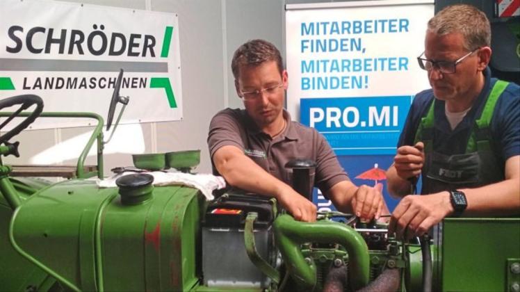 Bastian Kammann (links; Schröder Landmaschinen) zeigt Jens Kuraschinski einen Arbeitsschritt an einem Traktor. 