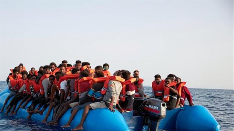 Flüchtlinge sitzen vor der Küste von Libyen in einem Schlauchboot. 
