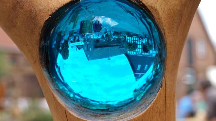 In der Glaskugel der Holzstele von Hobbykünstler Dietmar Reil spiegelt sich der Hof Seidel-Lott in Suttorf. Foto: Conny Rutsch