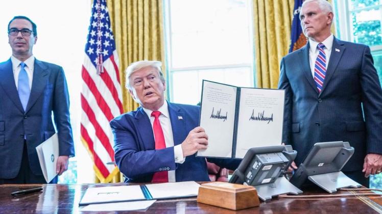 Seit gut einem Jahr verschärft sich der Streit zwischen den USA und Iran mehr und mehr. Ende Juni 2019 verabschiedet US-Präsident Donald Trump (hier mit Vize Mike Pence (rechts) und Finanzminister Steven Mnuchin) weitere Sanktionen, die Reaktionen aus Teheran lassen nicht lange auf sich warten. Foto: Mandel Ngan/AFP