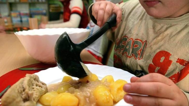 Ein Junge nimmt sich beim Mittagstisch des Kinderschutzbundes in Schwerin Soße für die Kartoffeln. 