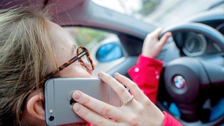 Nur noch schnell einen Anruf entgegennehmen: Viele Autofahrer können selbst am Steuer nicht auf ihr Handy verzichten. 