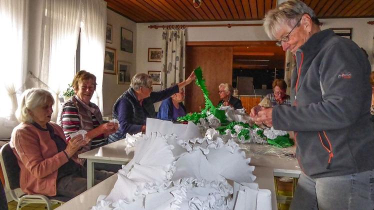 Fleißig sind die Osterberger Schützenfrauen dabei, 400 grün-weiße Papierrosen zu basteln. Foto: Ursula Holtgrewe