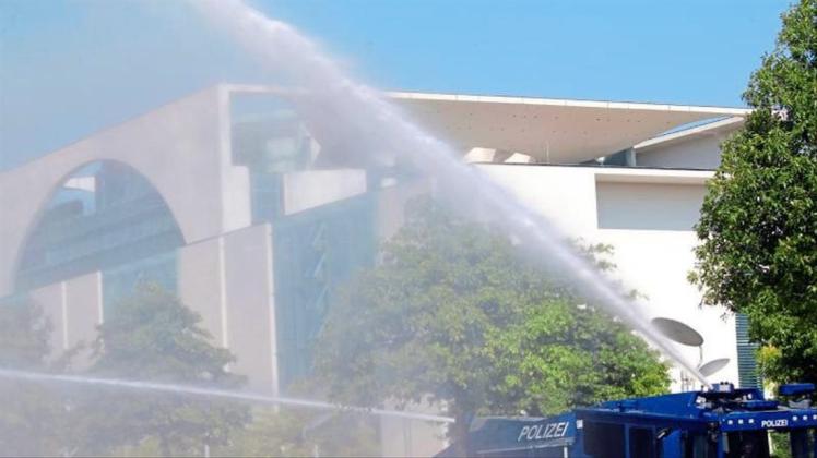 Bei Temperaturen um 30 Grad und extremer Trockenheit bewässert ein Wasserwerfer der Polizei die Grünanlagen vor dem Bundeskanzleramt. 