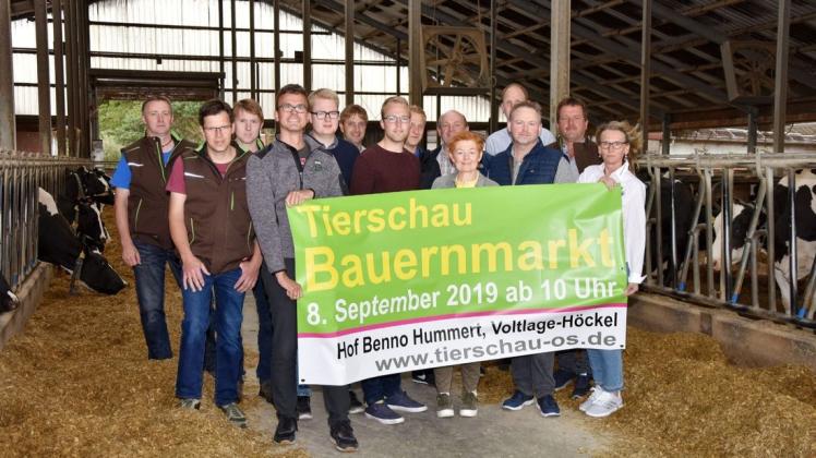 Im Kuhstall des Hofes Hummert präsentiert das Organisationsteam das große Einladungsplakat zum Bauernmarkt und zur Tierschau. Foto: Burkhard Dräger