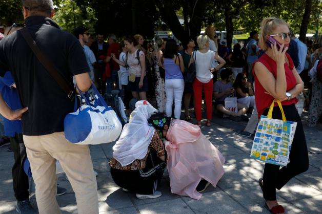 Menschen umarmen sich auf dem Syntagma-Platz nach dem Erdbeben. Foto: dpa/Petros Giannakouris