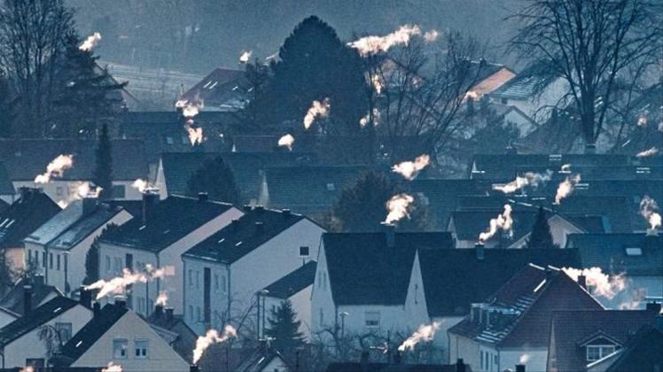 Schornsteine rauchen auf den Dächern der Häuser. Im Herbst sollen konkrete Maßnahmen und Gesetze für mehr Klimaschutz kommen. Foto: Armin Weigel/Archiv