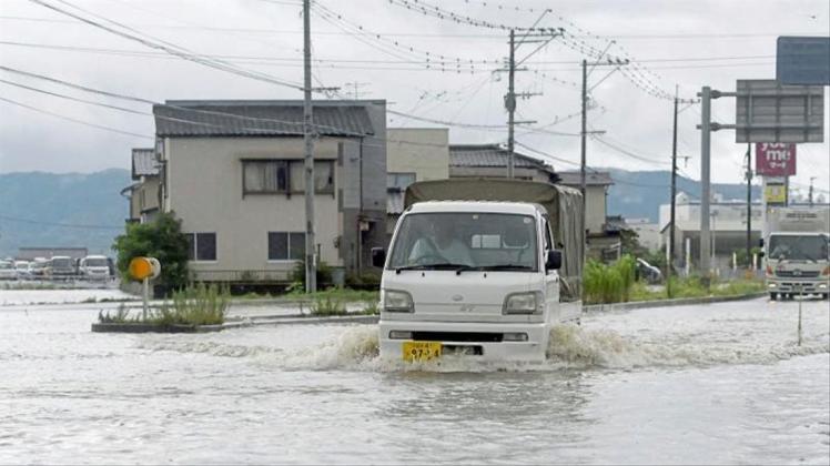 Eine Straße in Tachiarai in der Präfektur Fukuoka im Südwesten Japans steht nach starken Regenfälle unter Wasser. 