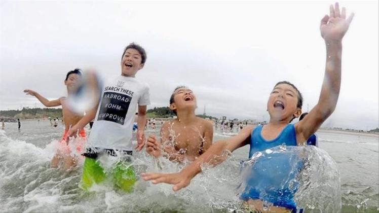 Kinder spielen im Wasser: Nach der Nuklearkatastrophe von Fukushima wurde der Strand zum ersten Mal wieder für Besucher zugelassen. 