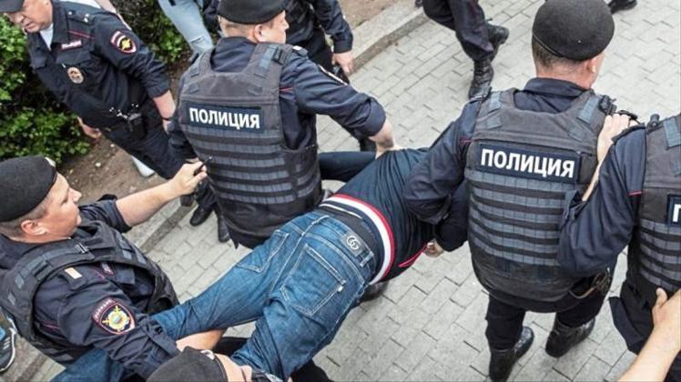 Polizisten tragen einen festgenommenen Demonstranten weg. Mehr als 200 Menschen sind in Moskau festgenommen worden. 