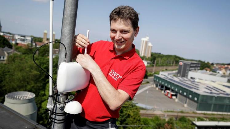 Systemtechniker Volker Korte installiert eine Lorawan-Antenne für das "Internet der Dinge" auf dem Dach des Stadtwerke-Gebäudes. Foto: David Ebener