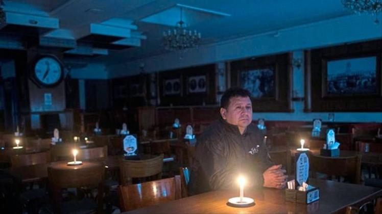 Ein Kunde sitzt in einer Bar in Buenos Aires während eines Stromausfalls. In Teilen Südamerikas ist es am Sonntag zu einem massiven Stromausfall gekommen. 